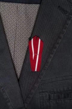 Latvian flag pin on a dark blue suit jacket Stock Photos