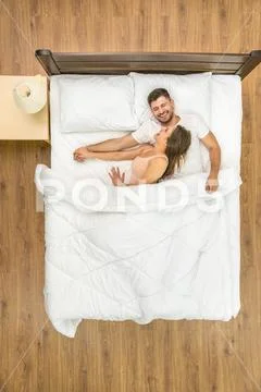 The laugh couple sleeping on the bed. View from above Stock Photos