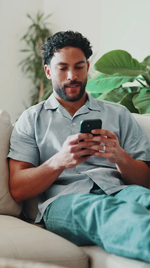 Laugh, phone and man on sofa with text message, online communication and comic Stock Footage 346945830