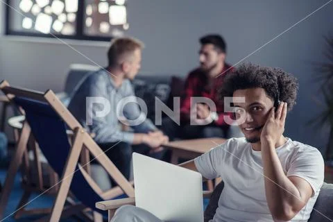 Laughing african american hipster software developer at computer at office of Stock Photos
