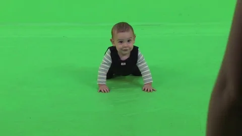 Laughing baby crawls towards the camera over a green screen. Stock Footage