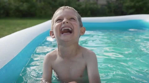 Laughing boy in garden pool Stock Footage 136918761