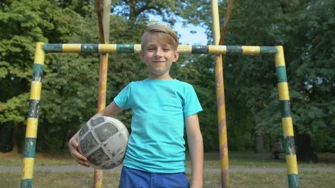 Laughing boy goalkeeper looking into camera, standing with ball at pitch, hobby Stock Footage 117208858
