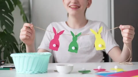 Laughing Boy made Easter paper garland. Multicolored Easter bunnies on string Stock-Footage 150111389