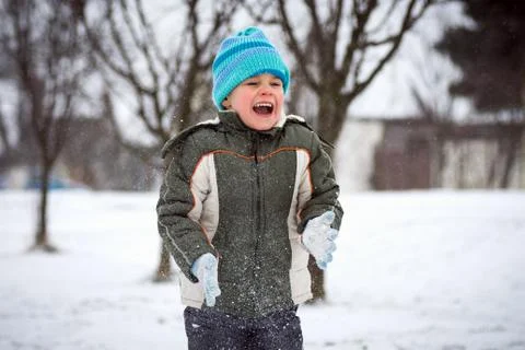 Laughing boy in snowfall Stock Photos
