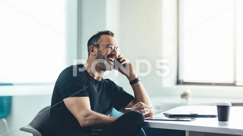 Laughing businessman on mobile phone Stock Photos