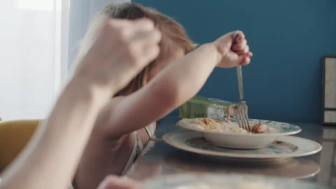 Laughing Child Playing with Fork During Family Breakfast at Home Stock Footage 336166305