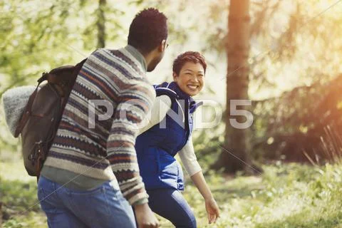 Laughing couple hiking with backpack in woods Stock Photos