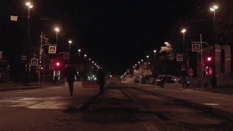 Laughing couple racing toward camera on closed for repairs night city road Stock Footage 73022253