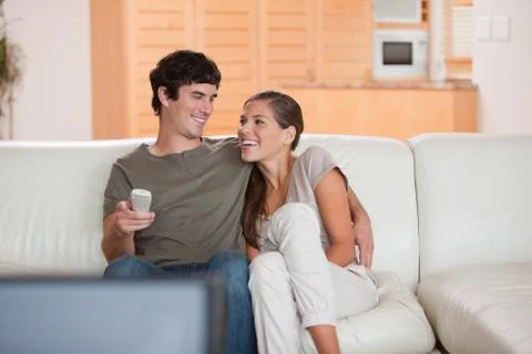 Laughing couple watching funny movie together Stock Photos