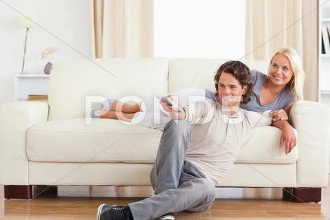 Laughing cute couple watching TV Stock Photos
