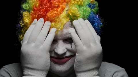 Laughing evil clown opens his face while taking away his hands Vídeos de archivo 124185721