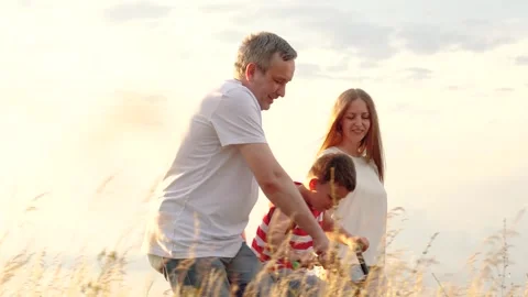 Laughing father pulls bike teaching son to ride at family weekend at countryside Stock Footage 246842947