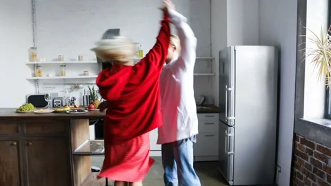 Laughing funny dancing couple kitchen home party Stock Footage 117852050