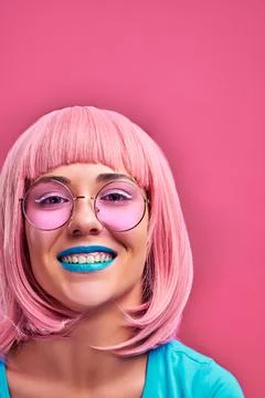 Laughing girl with pink hair, blue lips and sunglasses. Stylish hair color tr Stock Photos