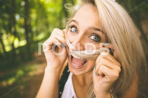 Laughing gorgeous blonde holding hair over mouth Stock Photos