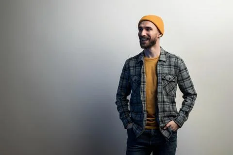 Laughing guy with a beard dressed in  checkered shirt and yellow hat holds hi Stock Photos