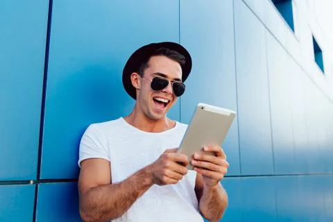 Laughing man using electronic tablet, outdoors Stock Photos
