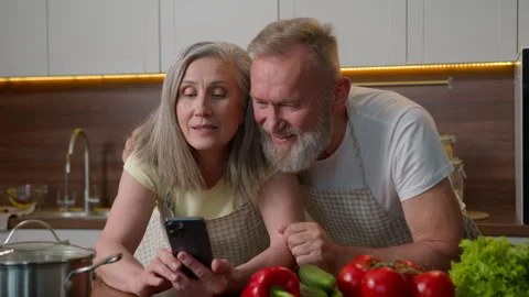 Laughing retired old gray haired Caucasian family love couple using mobile phone Stock Footage 249214814