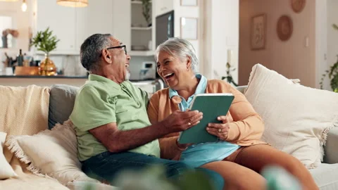 Laughing, retirement and tablet with old couple on sofa in living room of home Stock Footage 307673166