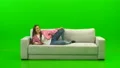 The laughing woman laying on the sofa on the green background 4k or 4k+ Resolution