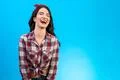 The laughing woman standing on the blue background Photo