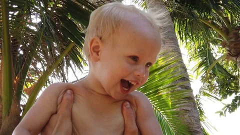  laughs two-year-old blond boy, father raises a child high. close up, slow motio Stock Footage 105594661