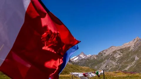 Laundry and flags in mountains. Clothes hanging to dry, flags waving in wind Stock Photos