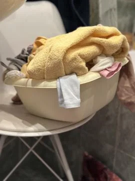 Laundry Basin Full of Clothes and Towels on a Chair 写真素材
