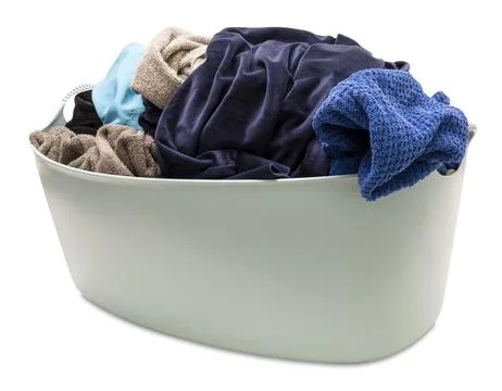 Laundry basket filled with assorted clothes in various colors, isolated on wh Stock Photos