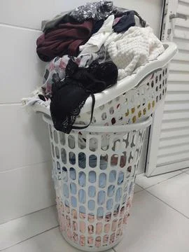 Laundry basket full of clothes Stock Photos