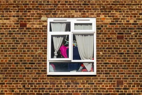 Laundry behind a window Stock Photos