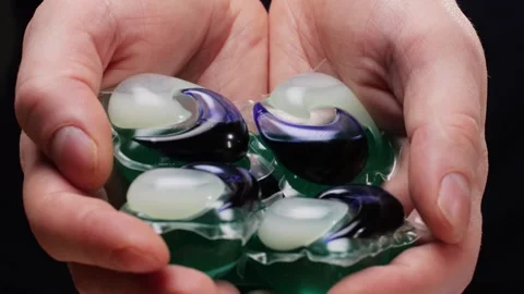 Laundry capsules for washing machine in man hands close-up. capsule contains Stock Footage 269452744