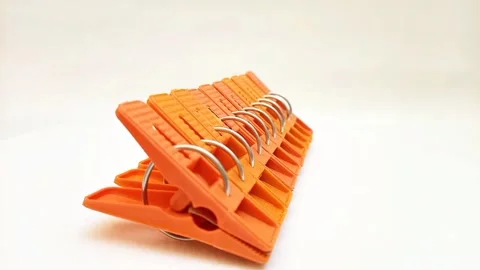 Laundry clips set, set of orange plastic clothes pins or clothes pegs on white Video stock 304688353
