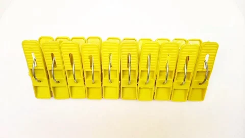 Laundry clips set, set of yellow plastic clothes pins or clothes pegs on white Stock Footage 304687544