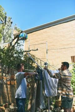 Laundry, clothes and helping with men in outdoor for sunshine, linen and fabric Stock Photos