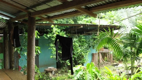 Laundry clothes hanging to dry under a roof while it is raining outside in a Stock Footage 142747892