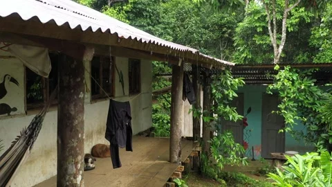 Laundry clothes hanging to dry under a roof while it is raining outside in a Stock Footage 142747943