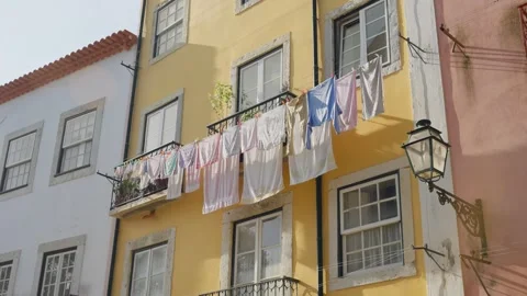 Laundry clothes hanging out to dry on balcony in colorful neighborhood in Lisbon Stock Footage 286854765
