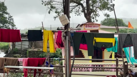 Laundry Clothes Hung On Clothesline Drench In The Rain. - slider shot Stock Footage 157141253