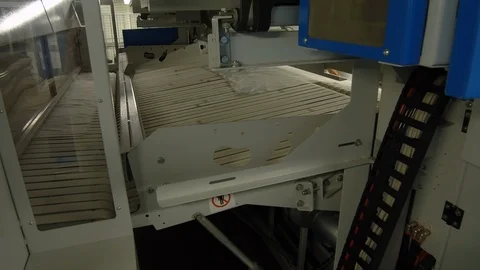 Laundry crew members inserting sheets in cruise ship laundry machine Stock Footage 117750896