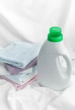 Laundry detergent bottle with clean folded towels Stock Photos