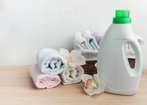 Laundry detergent bottle with fresh clean towels and orchids Stock Photos