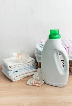 Laundry detergent bottle with fresh clean towels and orchids Stock Photos