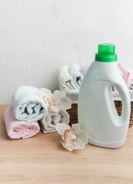 Laundry detergent bottle with fresh clean towels and orchids Stock Photos