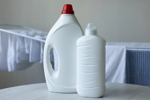 Laundry Detergent Bottles Near Drying Rack with Fresh Clean Laundry Fotos de archivo
