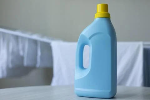 Laundry Detergent Bottles Near Drying Rack with Fresh Clean Laundry Fotos de archivo