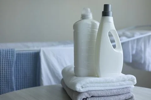 Laundry Detergent Bottles Near Drying Rack with Fresh Clean Laundry Fotos de archivo