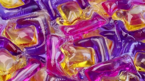 Laundry detergent pods rotating in circle with colorful gel texture and shiny Stock Footage 311237265