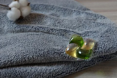 Laundry detergent pods on a soft towel with cotton flowers near the scene in a Stock Photos